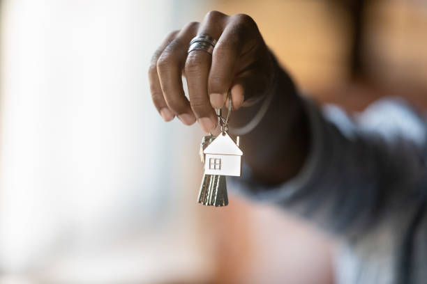 Welcome to new house. Close up of young african american man hand hold bunch of keys. Cropped shot of black guy real estate agent Real Estate Agent give offer you client key from home flat apartment. Copy space